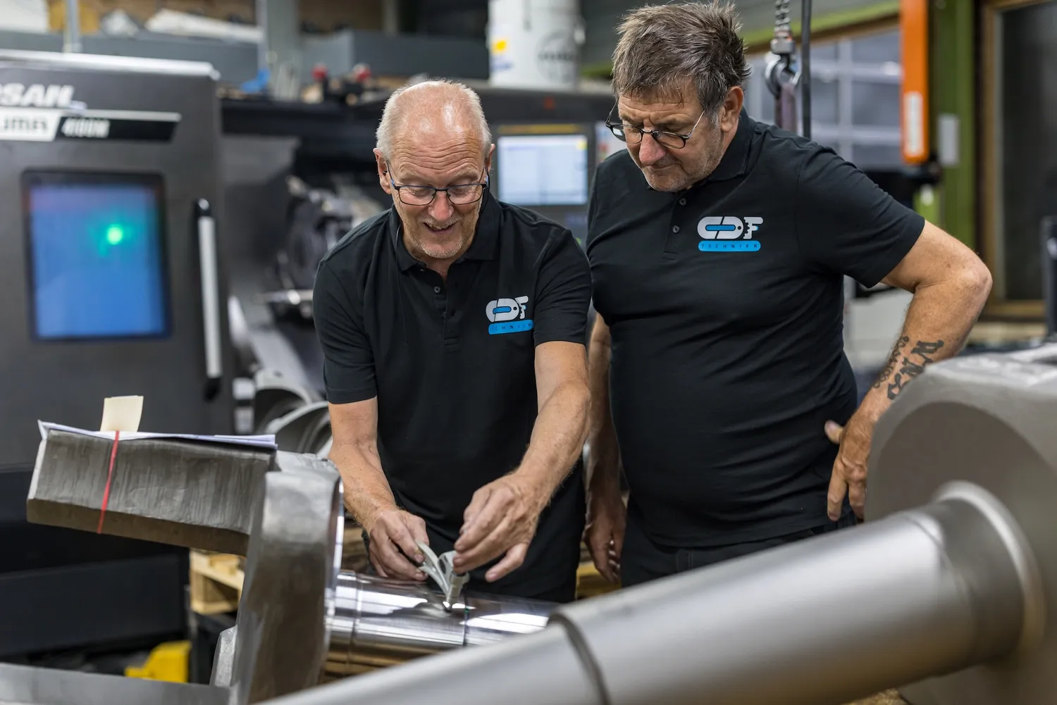 Vakmanschap bij CDF Techniek Twee ervaren medewerkers van CDF Techniek beoordelen een werkstuk
