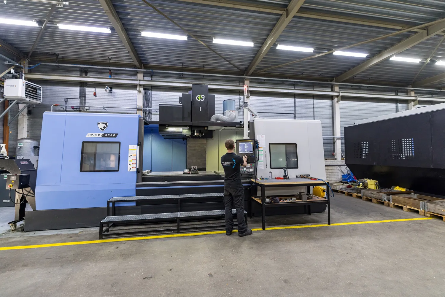 Medewerker bij een groot CNC bewerkingscentrum in de werkplaats