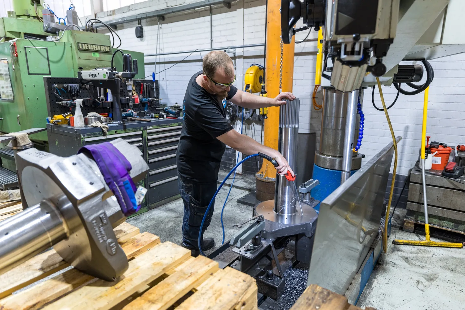 Zwaar werkstuk in de werkplaats Medewerker bij een groot en zwaar werkstuk in de werkplaats