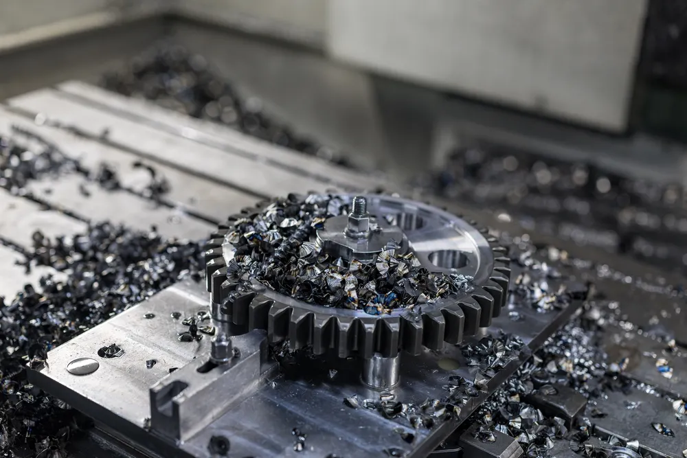 Gefreesd tandwiel tussen de spanen op de machinetafel